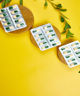 Flat lay Organic medical pills, capsules in blisters with green leaf, herbal plant Flat lay Organic medical pills, capsules in blisters with green leaf, herbal plant on a yellow background, Ethnoscience concept, view from above, copy space, healthe life.